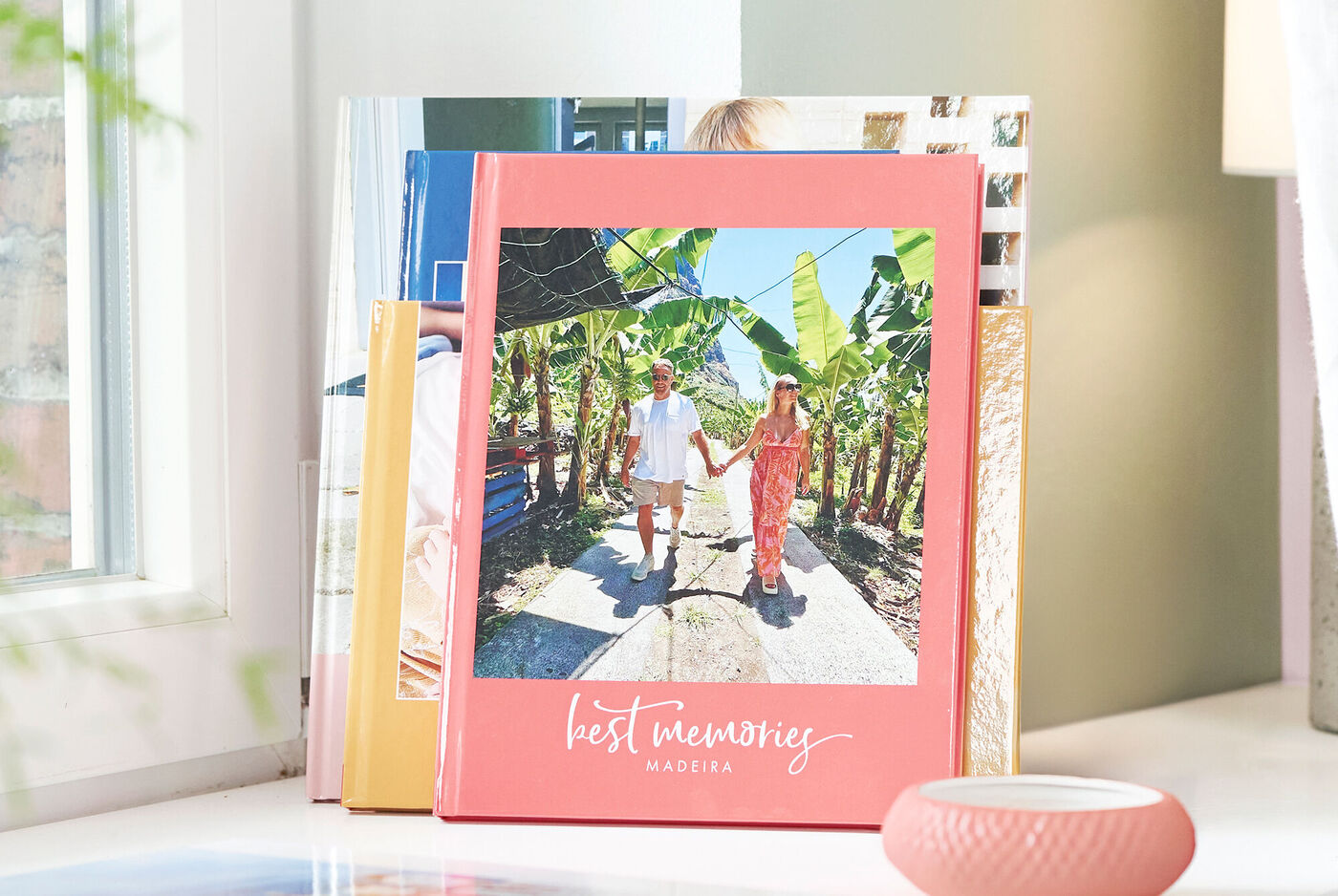 Paar loopt hand in hand op een pad tussen bananenbomen, omringd door een fotoboek getiteld 'Best Memories'.