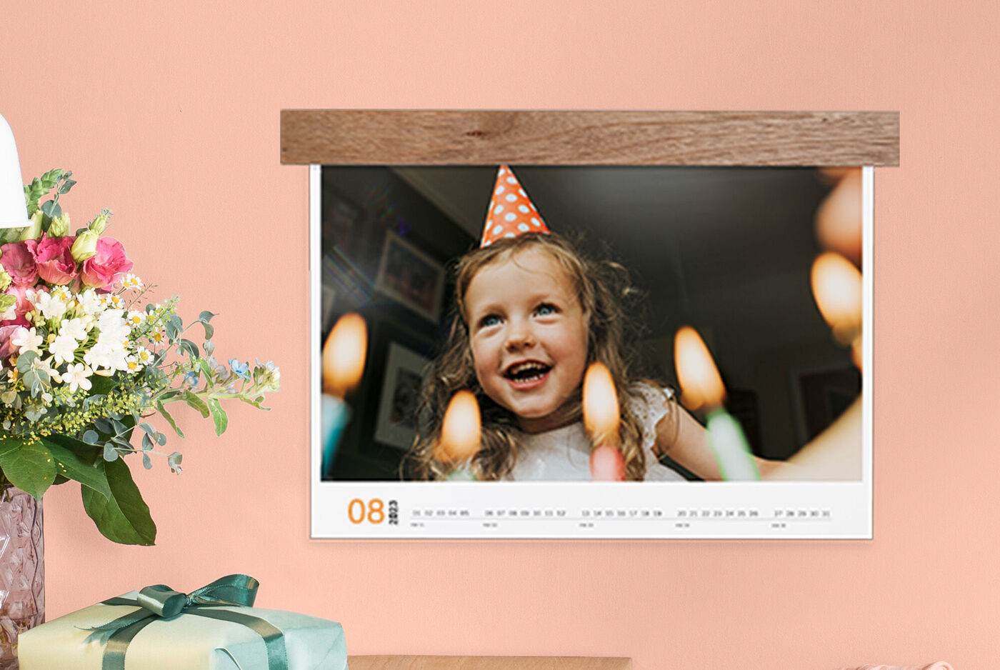 Een fotokalender met feestelijke kaarsen en een vrolijk kind met feesthoed